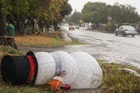 Christmas decorations are seen blown over by heavy winds in Carmel Valley, Calif., Monday, Dec. 13, 2021. A major storm hitting Northern California is expected to intensify and bring travel headaches and a threat of localized flooding after an abnormally warm fall in the U.S. West. (AP Photo/Nic Coury)