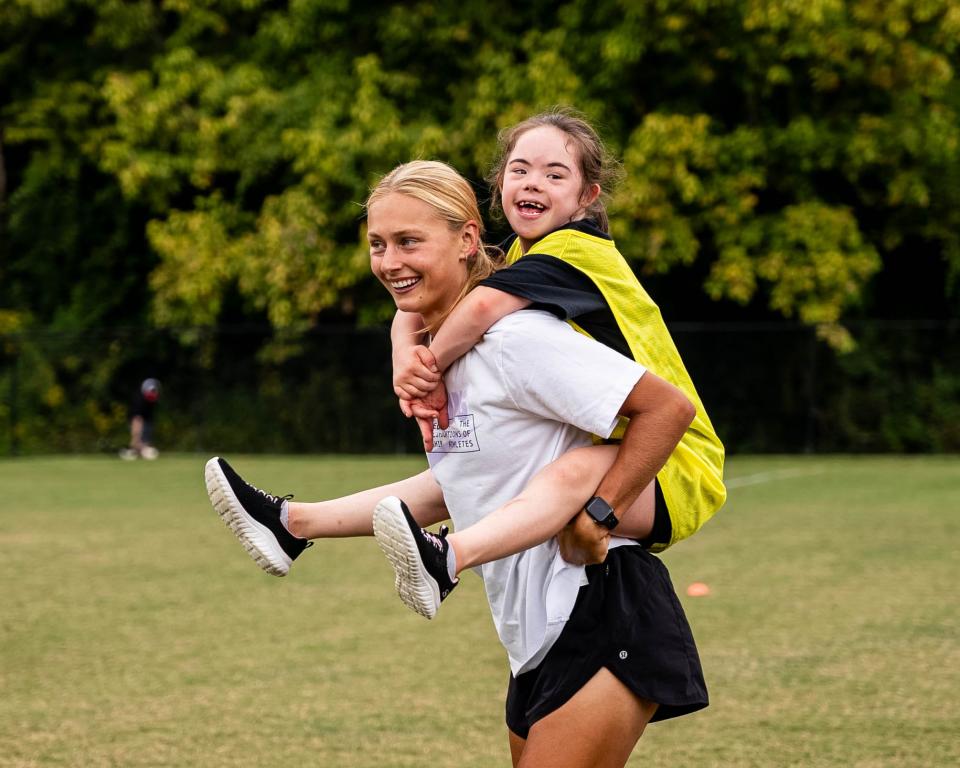 Racing FC midfielder Taylor Aylmer plays with a DSL member in between training sessions during the Rock Your Socks event.