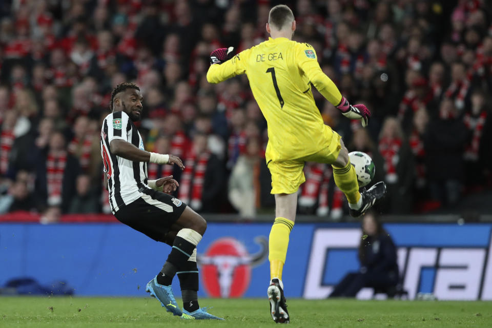 Manchester United's goalkeeper David de Gea, right, clears the ball in front Newcastle's Allan Saint-Maximin during the English League Cup final soccer match between Manchester United and Newcastle United at Wembley Stadium in London, Sunday, Feb. 26, 2023. (AP Photo/Scott Heppell)