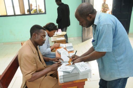 A voter (R) writes on a paper at a polling station in Moulia. Voters trickled to the polls in Gabon Saturday in legislative elections expected to hand a resounding victory to President Ali Bongo's party in the face of a boycott by some opposition groups