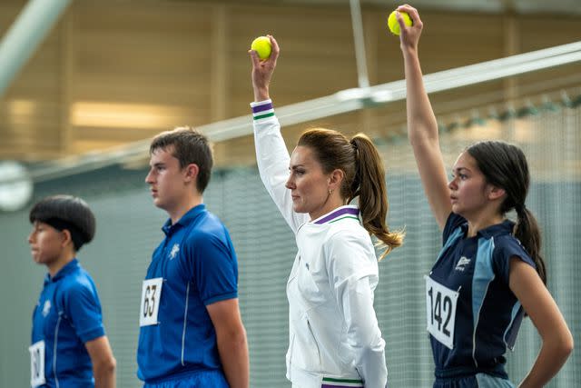 <p>Thomas Lovelock - AELTC via Getty </p> Kate Middleton practices with ball boys and girls before the Wimbledon Tennis Championships.