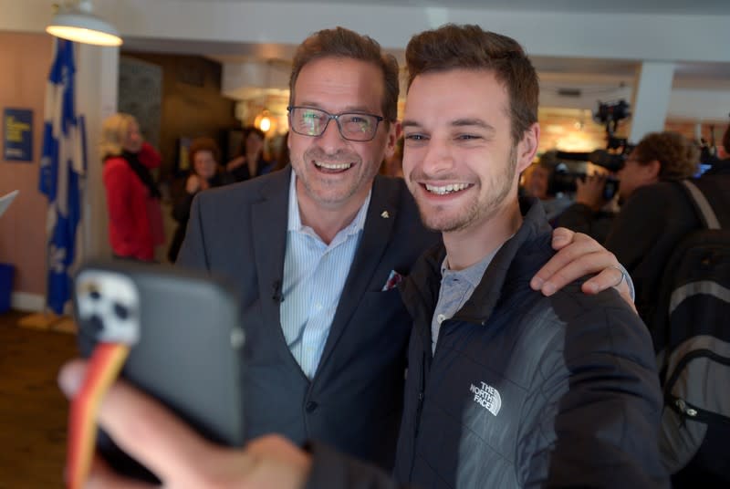 Bloc Quebecois leader Yves-Francois Blanchet poses for a selfie with his supporter at the electoral office in Beloeil, Quebec