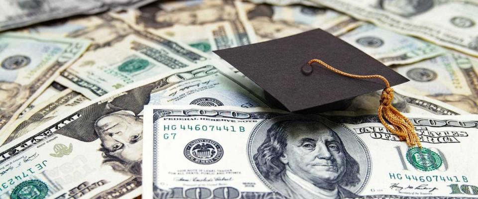 mini graduation cap on US money -- education costs