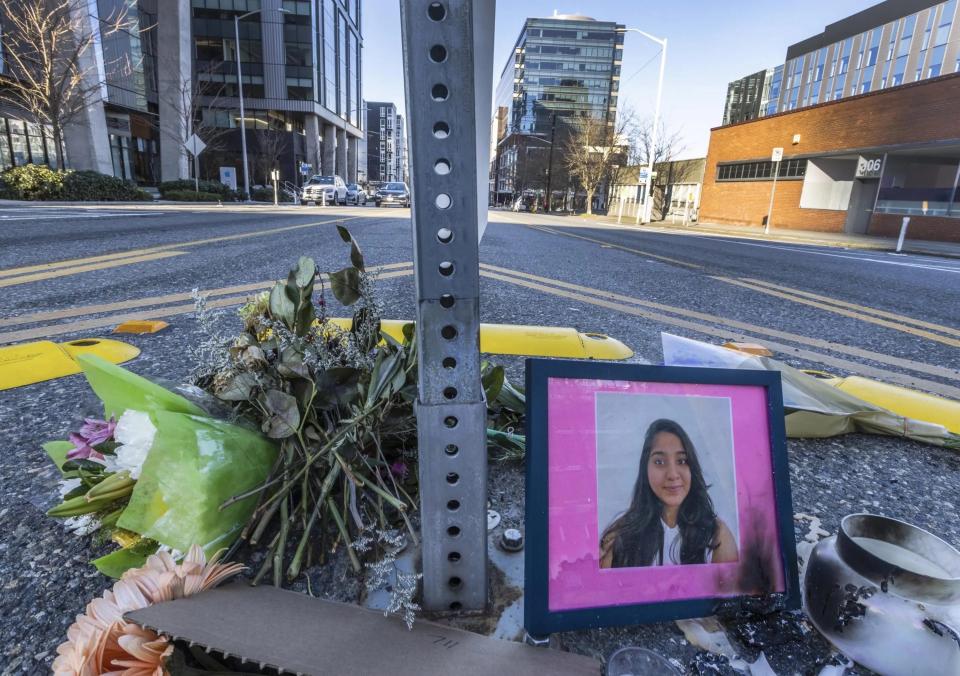 A photo of Jaahnavi Kandula is seen with flowers, Sunday, Jan. 29, 2023, in Seattle, at the intersection where she was killed by a Seattle Police officer driving north while responding to a nearby medical incident.