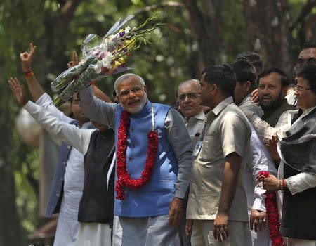 Hindu nationalist Narendra Modi (wearing a garland), the prime ministerial candidate for India's Bharatiya Janata Party (BJP), gestures to his supporters outside party's headquarters in New Delhi May 17, 2014. REUTERS/Ahmad Masood