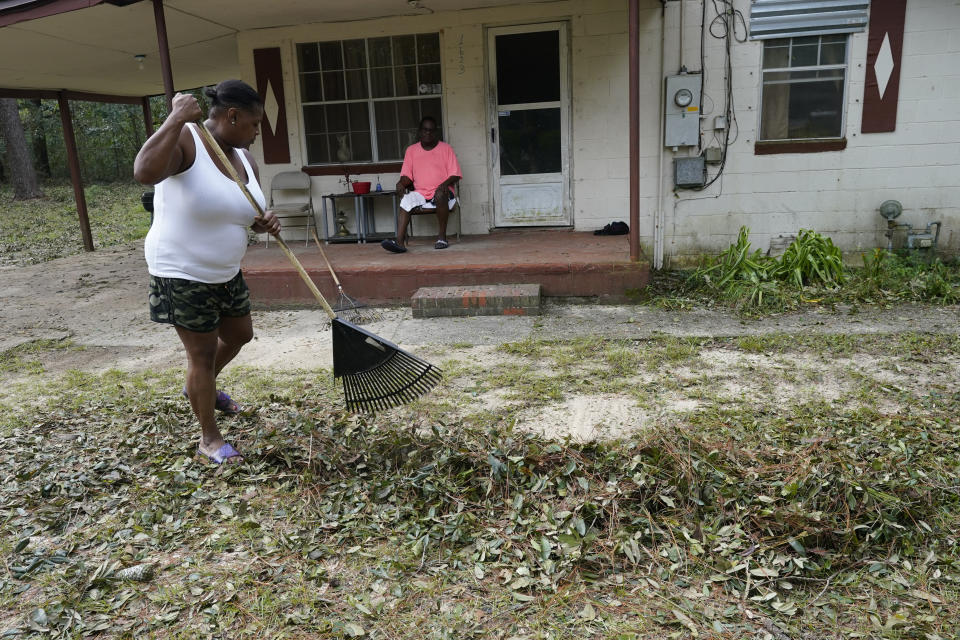 Mamie Patterson helps her cousin Kenneth Bargaineer, right, clean up after Hurricane Sally, Friday, Sept. 18, 2020, in Pensacola, Fla. (AP Photo/Gerald Herbert)