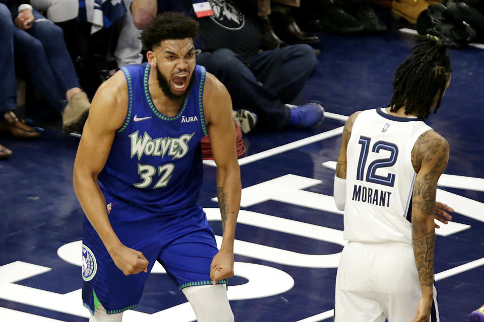 Minnesota Timberwolves center Karl-Anthony Towns (32) celebrates after dunking as Memphis Grizzlies guard Ja Morant (12) walks to the bench in the first half in Game 6 of an NBA basketball first-round playoff series Friday, April 29, 2022, in Minneapolis. (AP Photo/Andy Clayton-King)