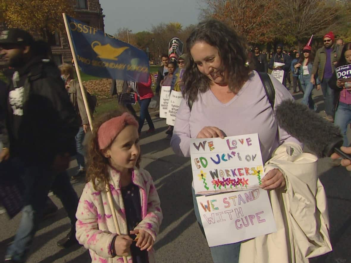 Andrea Wobick went to Queen's Park with her six-year-old daughter to protest beside CUPE education workers fighting against the Ford government's new anti-strike bill. (Pelin Sidki/CBC - image credit)