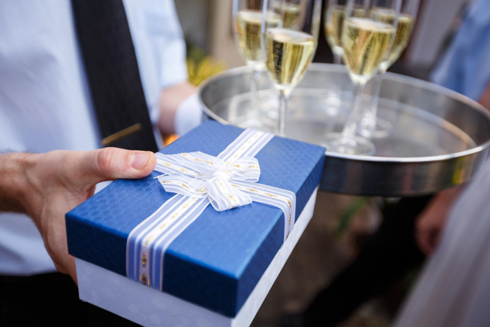 hands holding a drink tray and a gift