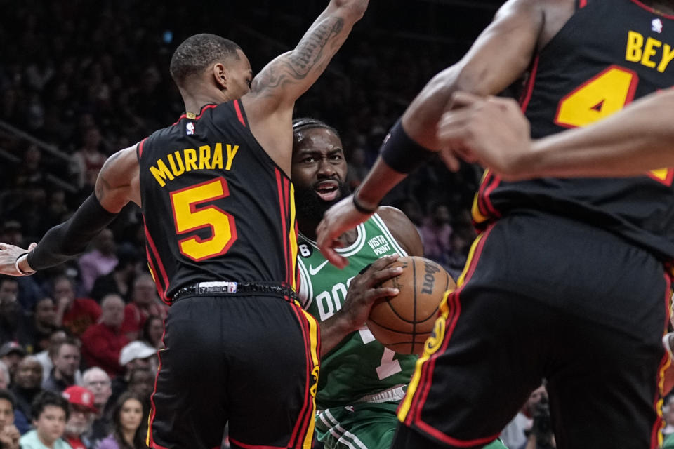 Boston Celtics guard Jaylen Brown (7) defends the ball against Atlanta Hawks guard Dejounte Murray (5) during the first half of Game 4 of a first-round NBA basketball playoff series, Sunday, April 23, 2023, in Atlanta. (AP Photo/Brynn Anderson)