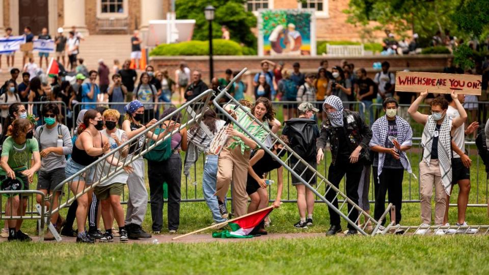 Palestinian demonstrators remove a barrier surrounding a flagpole after a rally at the South Building Tuesday, April 30, 2024 at UNC-Chapel Hill. A “Gaza solidarity encampment” was removed by police early Tuesday morning.