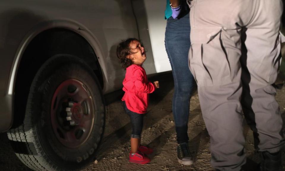 A two-year-old Honduran asylum seeker cries as her mother is searched and detained near the US-Mexico border on 12 June 2018 in McAllen, Texas.