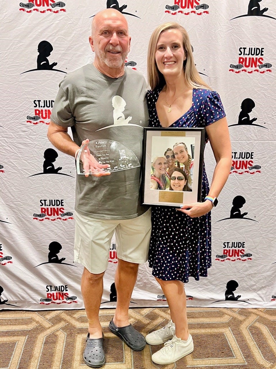 Kevin Paulter and his daughter Jeri Paulter pose with an award commemorating their years of participation in the St. Jude Memphis to Peoria run.