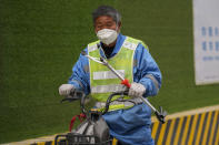 A municipal worker rides a bicycle on a street in Beijing, China, Thursday, March 21, 2024. China’s first generation of migrant workers played an integral role in the country's transformation from an impoverished nation to an economic powerhouse. Now, they're finding it hard to find work, both because they're older and the economy is slowing. (AP Photo/Tatan Syuflana)