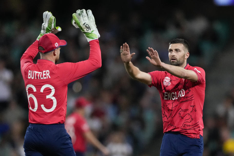 England's Jos Buttler, left, congratulates teammate Mark Wood after dismissing Sri Lanka's Dasun Shanaka during the T20 World Cup cricket match between England and Sri Lanka in Sydney, Australia, Saturday, Nov. 5, 2022. (AP Photo/Rick Rycroft)