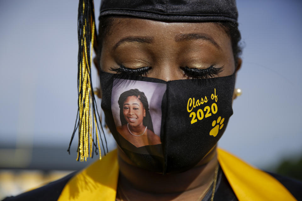 Graduating senior Yasmine Protho, 18, wears a photo of herself and Class of 2020 on her protective mask amid the coronavirus pandemic as she graduates with only 9 other classmates at a time with limited family attending at Chattahoochee County High School on Friday, May 15, 2020, in Cusseta, Ga. (AP Photo/Brynn Anderson)