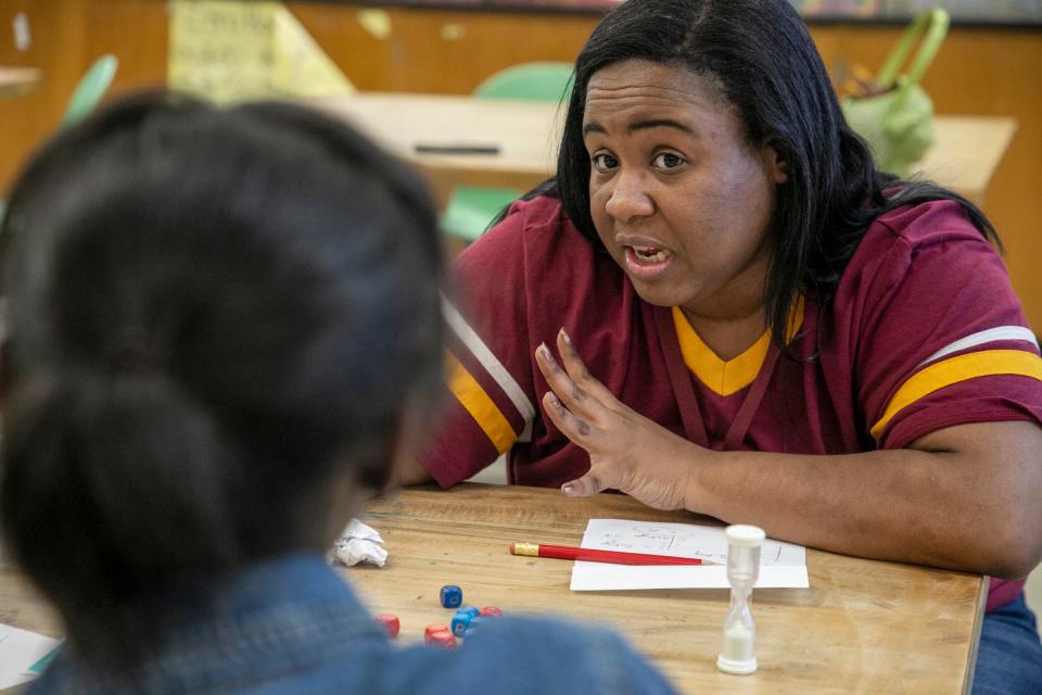 Coach Stephanie Henyard, 33, of Detroit, plays a round of WFF’N Proof to prepare students for the upcoming Michigan League of Academic Games Super Tournament after school at Foreign Language Immersion and Cultural Studies School in Detroit on Tuesday, Feb. 6, 2024. Coach Henyard played in the academic games when she went to Bates Elementary and at Renaissance High School in Detroit and she says it gave her confidence and lifelong friendship with other players she met.