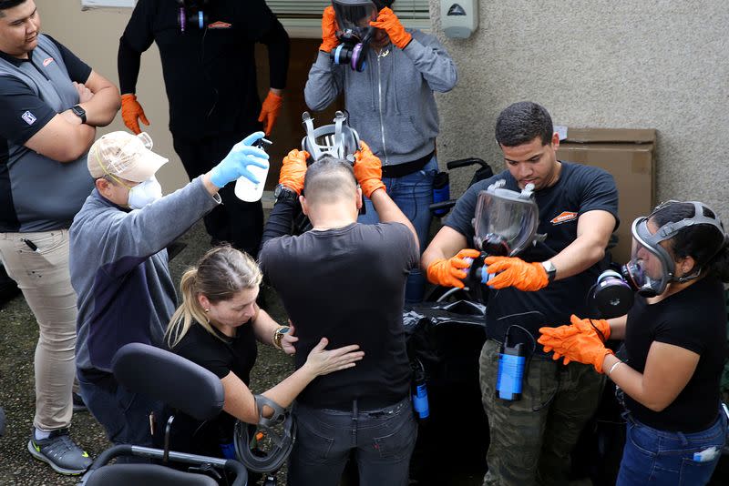 Cleaning crew from Servpro remove their protective gear outside the Life Care Center of Kirkland in Washington