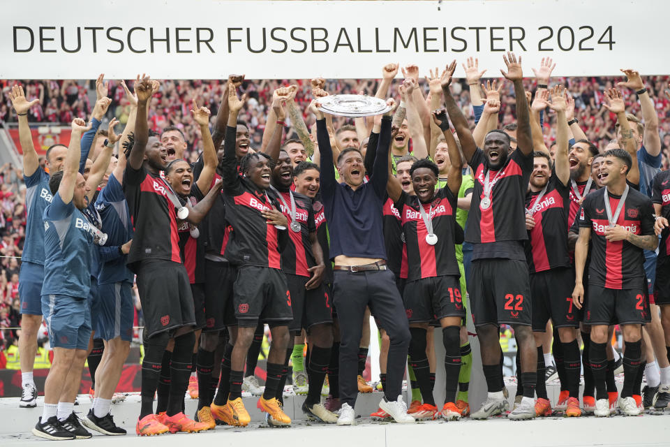 Leverkusen's head coach Xabi Alonso celebrates with the trophy as his team won the German Bundesliga, after the German Bundesliga soccer match between Bayer Leverkusen and FC Augsburg at the BayArena in Leverkusen, Germany, Saturday, May 18, 2024. Bayer Leverkusen have won the Bundesliga title for the first time. It is the first team in Bundesliga history, that won the championship unbeaten for the whole season. (AP Photo/Martin Meissner)