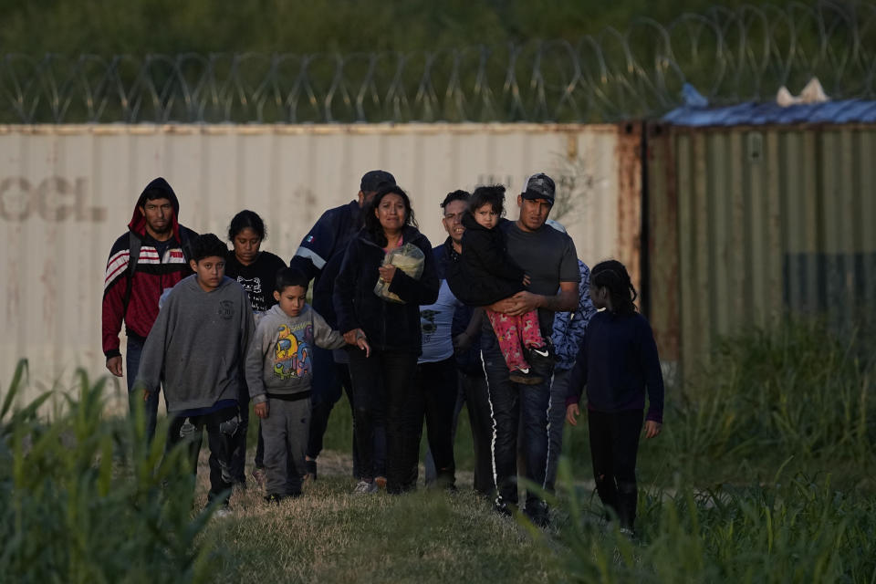 Migrants walk past a barrier after they crossed the Rio Grande and entered the U.S. from Mexico, Thursday, Oct. 19, 2023, in Eagle Pass, Texas. Starting in March, Texas will give police even broader power to arrest migrants while also allowing local judges to order them out of the U.S. under a new law signed by Republican Gov. Greg Abbott. (AP Photo/Eric Gay)