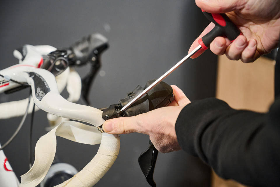 Bayton adjusting the positioning of the hoods on the handlebars of Simon Fellows' bike