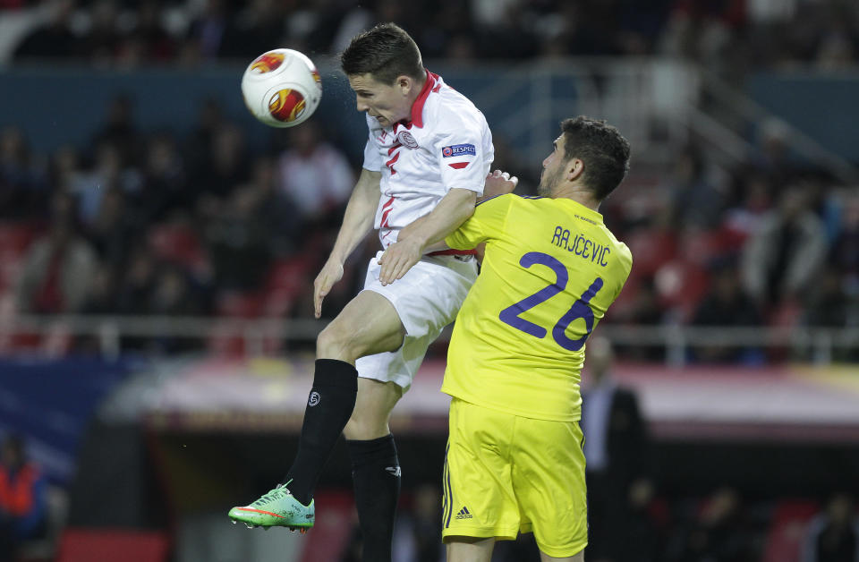 Sevilla's Kevin Gameiro, left beats Maribor's Aleksander Rajcevic to a header during their Europa League round of 32, 2nd leg soccer match at the Ramon Sanchez Pizjuan stadium in Seville, Spain Thursday Feb. 27, 2014. (AP Photo/Toni Rodriguez)