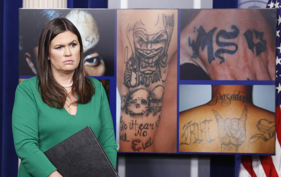 White House press secretary Sarah Sanders stands in front of pictures of MS-13 gang tattoos during a press briefing in July 2017. (Photo: Alex Brandon/AP)