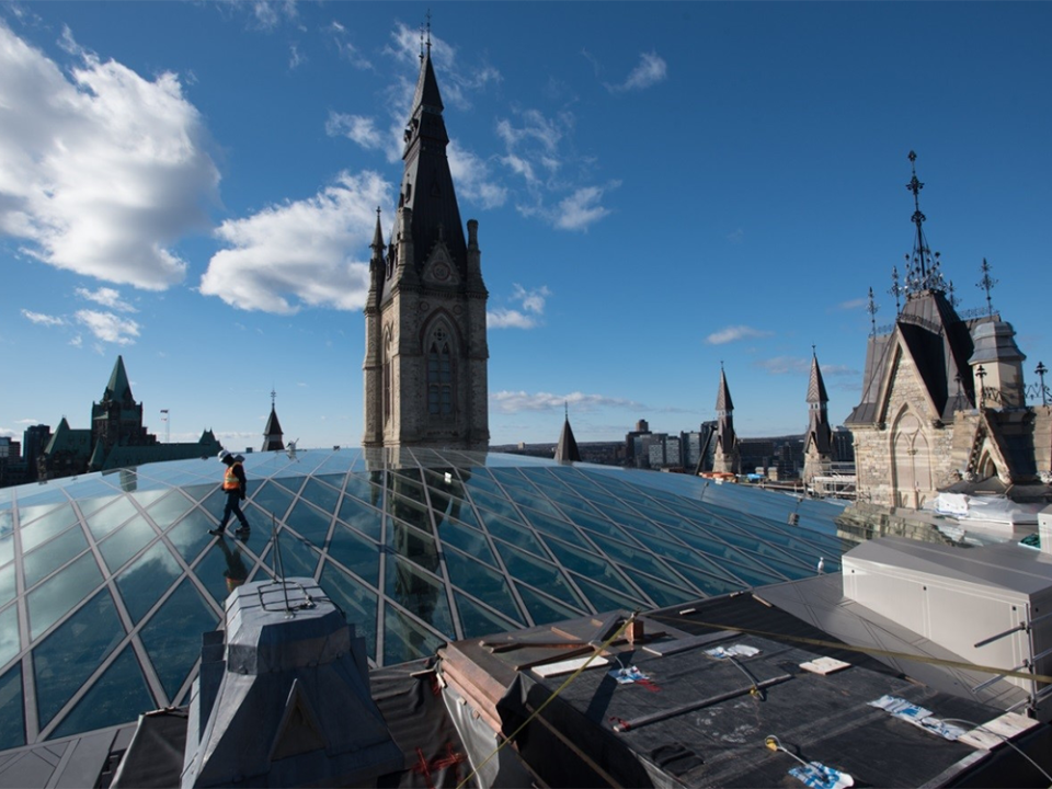  A worker walks across the glass roof of the House of Parliament’s West Block in Ottawa.