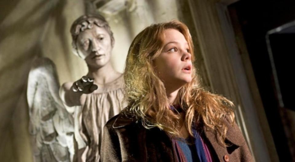 Carey Mulligan in front of an angel statue