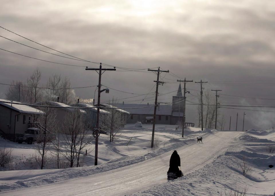 A snowmobile rides down the main street Tuesday, Dec. 18, 2012, on the Fort Hope First Nation, Ont. A major player in developing the much-touted Ring of Fire project in northern Ontario says it will consider pulling out if the Ontario government doesn't ensure the company has access to the chromite deposit.