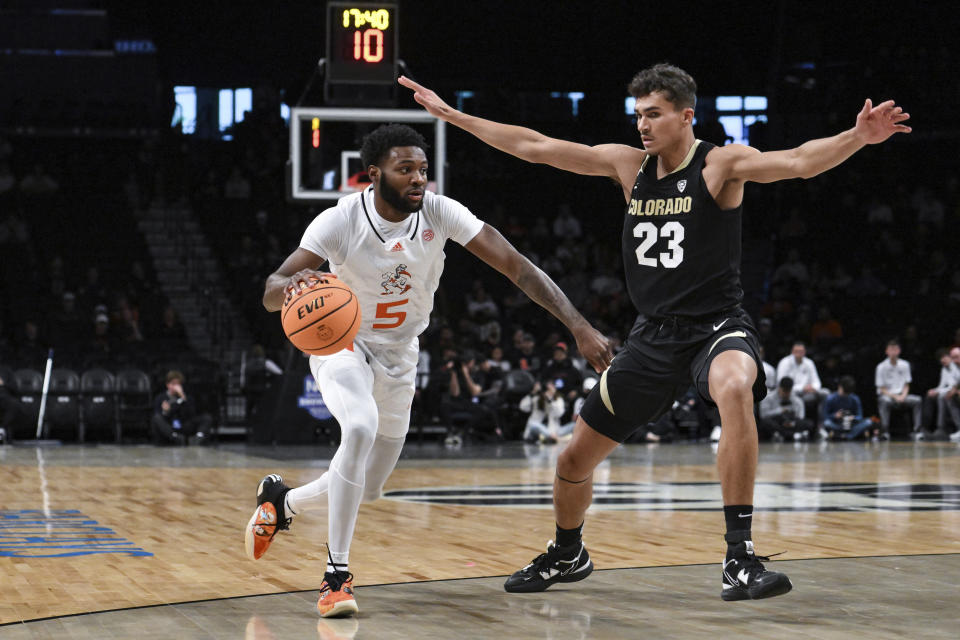 Miami guard Wooga Poplar (5) drives to the basket against Colorado forward Tristan da Silva (23) during the first half of an NCAA college basketball game in the NABC Brooklyn Showcase, Sunday, Dec. 10, 2023, in New York. (AP Photo/John Jones)