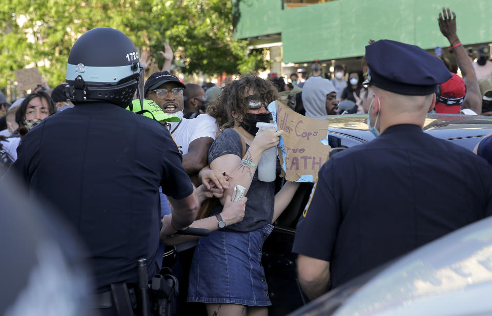 New York Police officers push back protesters during a demonstration Saturday, May 30, 2020, in the Brooklyn borough of New York. Protests were held throughout the city over the death of George Floyd, a black man who was in police custody in Minneapolis. Floyd died after being restrained by Minneapolis police officers on Memorial Day. (AP Photo/Seth Wenig)