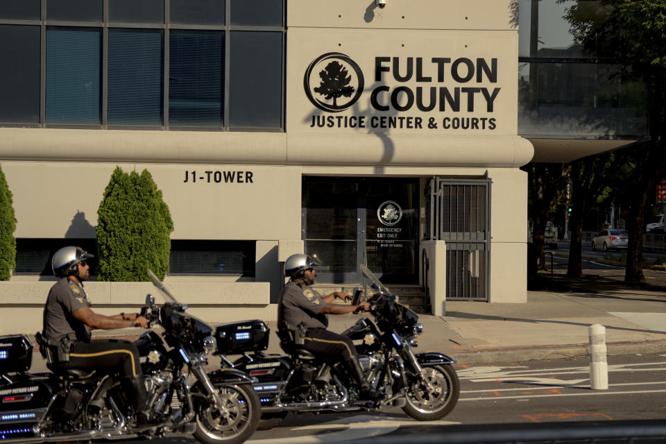 Camiones de producción de televisión se alinean en la calle fuera del tribunal del condado de Fulton en Atlanta, el 14 de agosto de 2023. (Amir Hamja/The New York Times)
