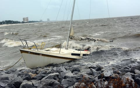 An abandoned boat takes on water on the Mississippi Gulf Coast, Saturday, Oct. 7, 2017 - Credit: AP