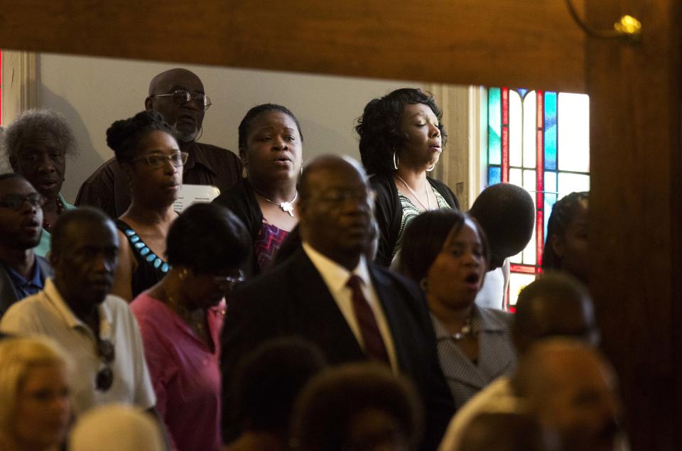 Parishioners applaud during a memorial service at Morris Brown AME Church for the nine people killed Wednesday during a prayer meeting inside a historic black church in Charleston, S.C., Thursday, June 18, 2015. (AP Photo/David Goldman)