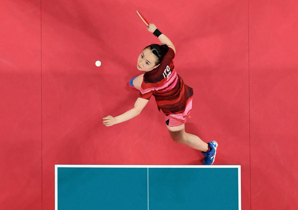 <p>Japan's Mima Ito hits a shot against China's Xu Xin and Liu Shiwen (not pictured) in their July 26 mixed doubles table tennis final match.</p>