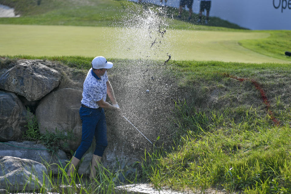 Bo Hoag hits while standing ankle-deep in water on the 18th hole during the third round of the 3M Open golf tournament in Blaine, Minn., Saturday, July 24, 2021. (AP Photo/Craig Lassig)