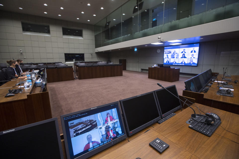 Additional judges, the prosecution and defense lawyers are seen on screens via video link due to COVID-19 measures, at the start of the session of the United Nations-backed Lebanon Tribunal where it is scheduled to hand down it's sentencing on Salim Jamil Ayyash, a member of the Hezbollah militant group who was convicted of involvement in the assassination of former Lebanese Prime Minister Rafik Hariri and 21 others 15 years ago, in Leidschendam, Netherlands, Friday Dec. 11, 2020. Ayyash is not in custody and is unlikely to serve any sentence. (AP Photo/Peter Dejong, Pool)