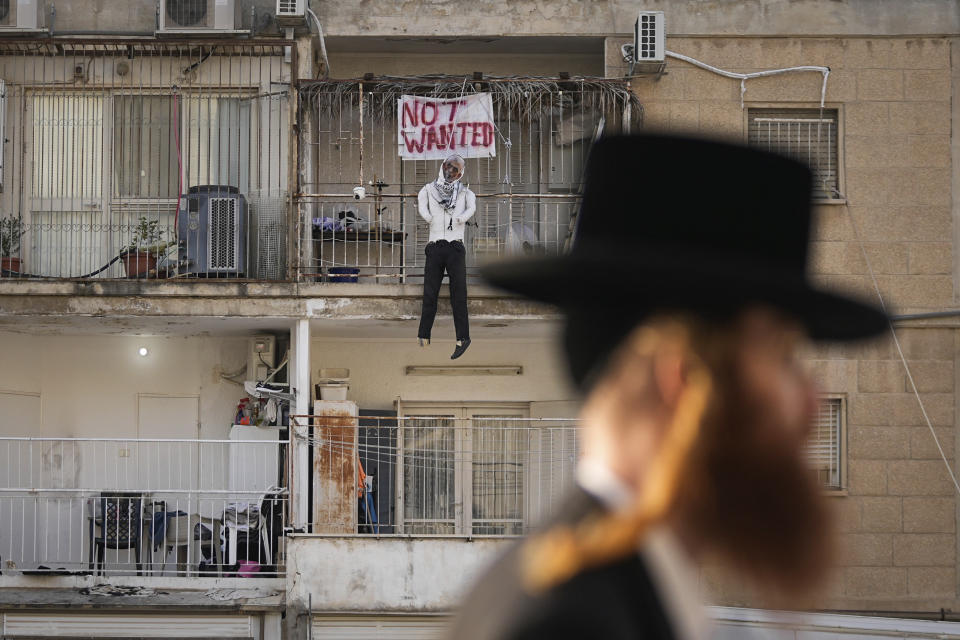 An effigy of Hamas leader Yehya Sinwar hangs off the balcony of an apartment under the sign "Not Wanted" in Jerusalem on Thursday, March 28, 2024. Israel says Sinwar is the mastermind of Hamas' deadly cross-border attack on Oct. 7 and says he remains in hiding in Gaza. (AP Photo/Ohad Zwigenberg)