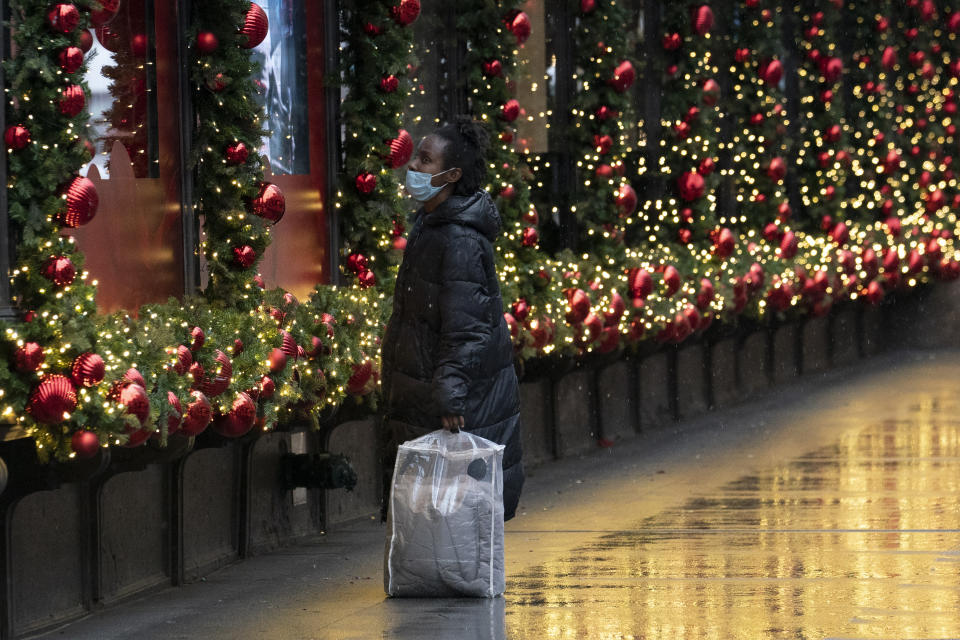 A shopper looks at Macy's window displays, Monday, Nov. 30, 2020, in New York. (AP Photo/Mark Lennihan)