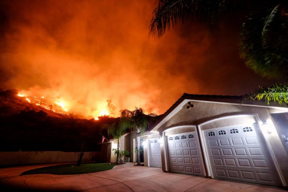 A wildfire burns near homes in the Cleveland National Forest (AP)