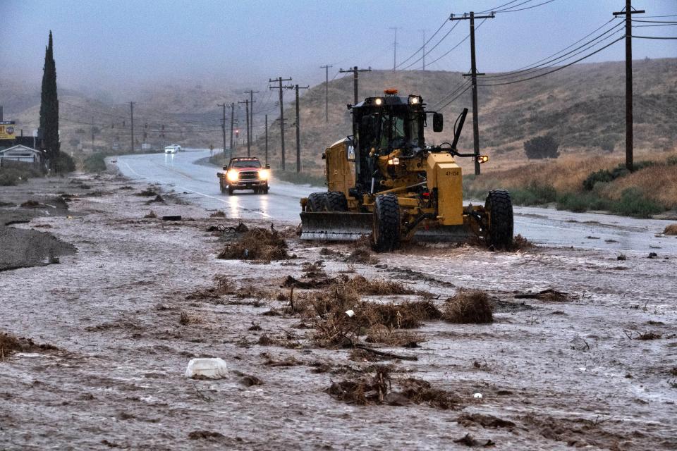 A plow clears debris along a flooded Sierra Highway in Palmdale, Calif., as Tropical Storm Hilary moves through the area on Sunday, Aug. 20, 2023. (AP Photo/Richard Vogel)