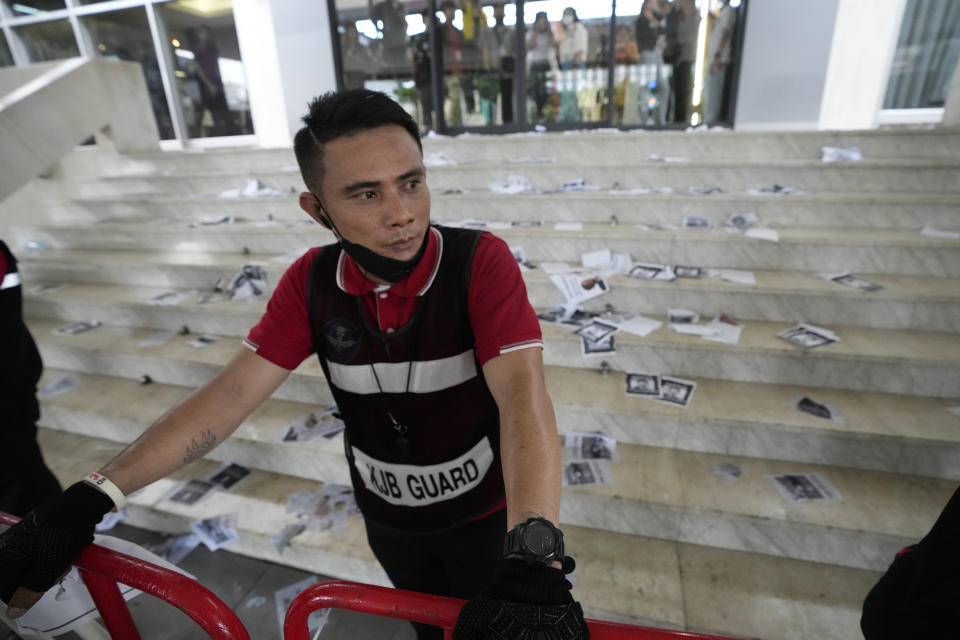 Security guard stand guard in front of the Thai Party headquarters after protester throw leaflets demanding Leader of Pheu Thai party Chonlanan Srikaew resign at the party headquarters in Bangkok, Thailand, Monday, Aug. 7, 2023. The populist Pheu Thai Party on Monday announced it will assemble a coalition with the Bhumjaithai Party from the outgoing administration to solve the months long political deadlock. (AP Photo/Sakchai Lalit)