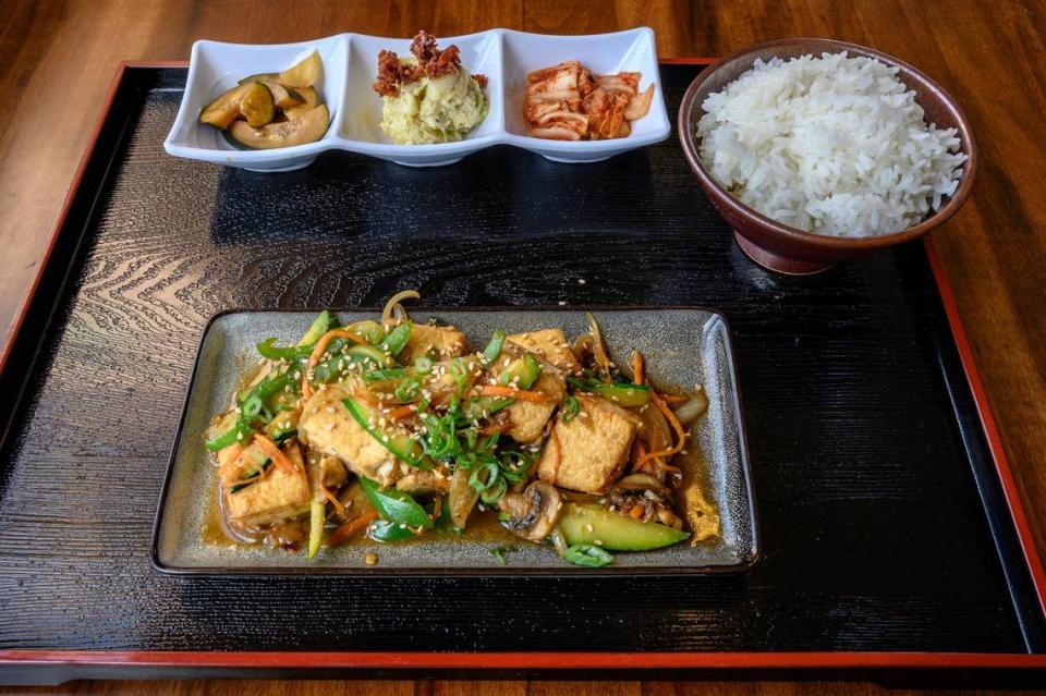 Kai Jung, chef and co-owner of Kuji Asian Grill in Woodland serves his tofu stir-fry on a tray Friday, March 9, 2019.