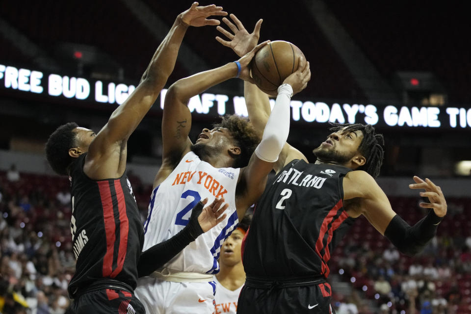 New York Knicks' Miles McBride, center, attempts a shot againstPortland Trail Blazers' Brandon Williams, left, and Trendon Watford, right, during the first half an NBA summer league championship basketball game Sunday, July 17, 2022, in Las Vegas. (AP Photo/John Locher)