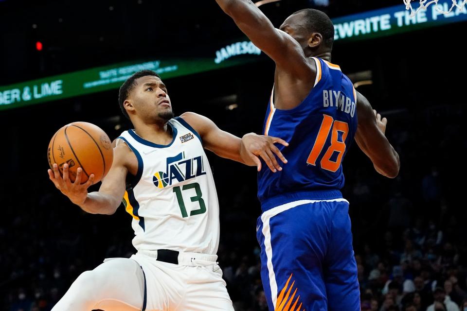 Utah Jazz guard Jared Butler (13) shoots around Phoenix Suns forward Bismack Biyombo (18) during the first half of an NBA basketball game, Monday, Jan. 24, 2022, in Phoenix. (AP Photo/Matt York)