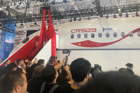 People attend an unveiling ceremony for a life-size model of wide-body jet CR929 developed by China-Russia Commercial Aircraft International Corporation (CRAIC), a joint venture between Commercial Aircraft Corporation of China (COMAC) and Russia's United Aircraft Corp (UAC), at the China International Aviation and Aerospace Exhibition, or Zhuhai Airshow, in Zhuhai, Guangdong province, China November 6, 2018. REUTERS/Tim Hepher