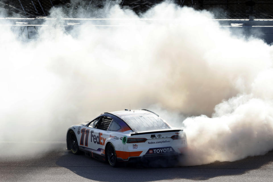 Denny Hamlin does a burnout as he celebrates after winning a NASCAR Cup Series auto race at Kansas Speedway in Kansas City, Kan., Sunday, May 7, 2023. (AP Photo/Colin E. Braley)