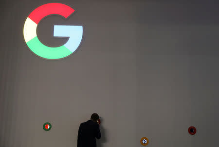 A man checks Google devices outside its booth at the Mobile World Congress in Barcelona, Spain, February 27, 2018. REUTERS/Sergio Perez/Files