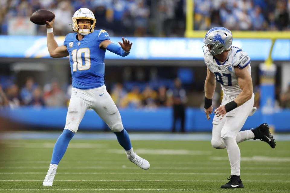 Chargers quarterback Justin Herbert passes in front of Lions defensive end Aidan Hutchinson in the second half.